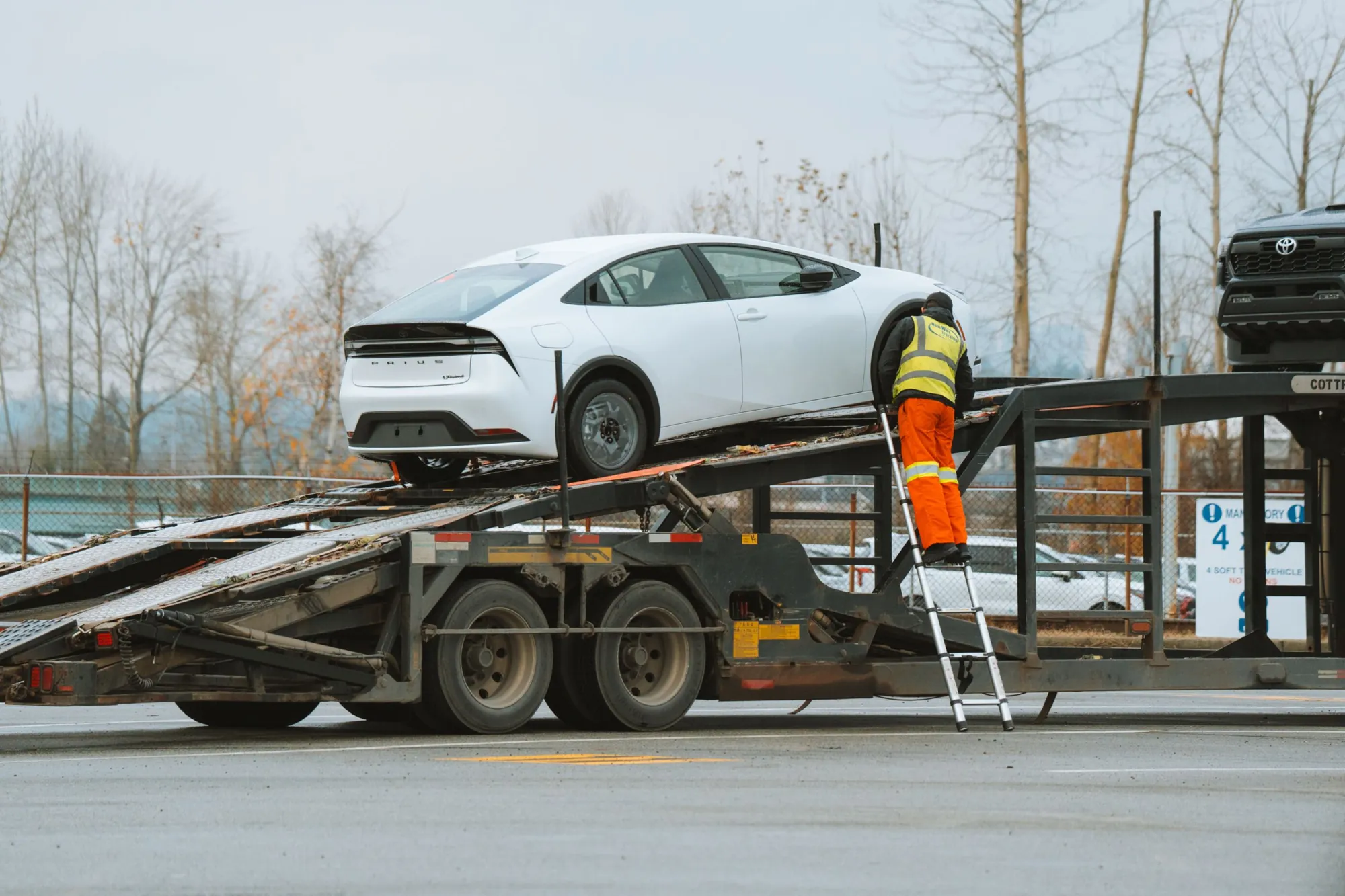 Operator care încarcă un autoturism pe platforma auto