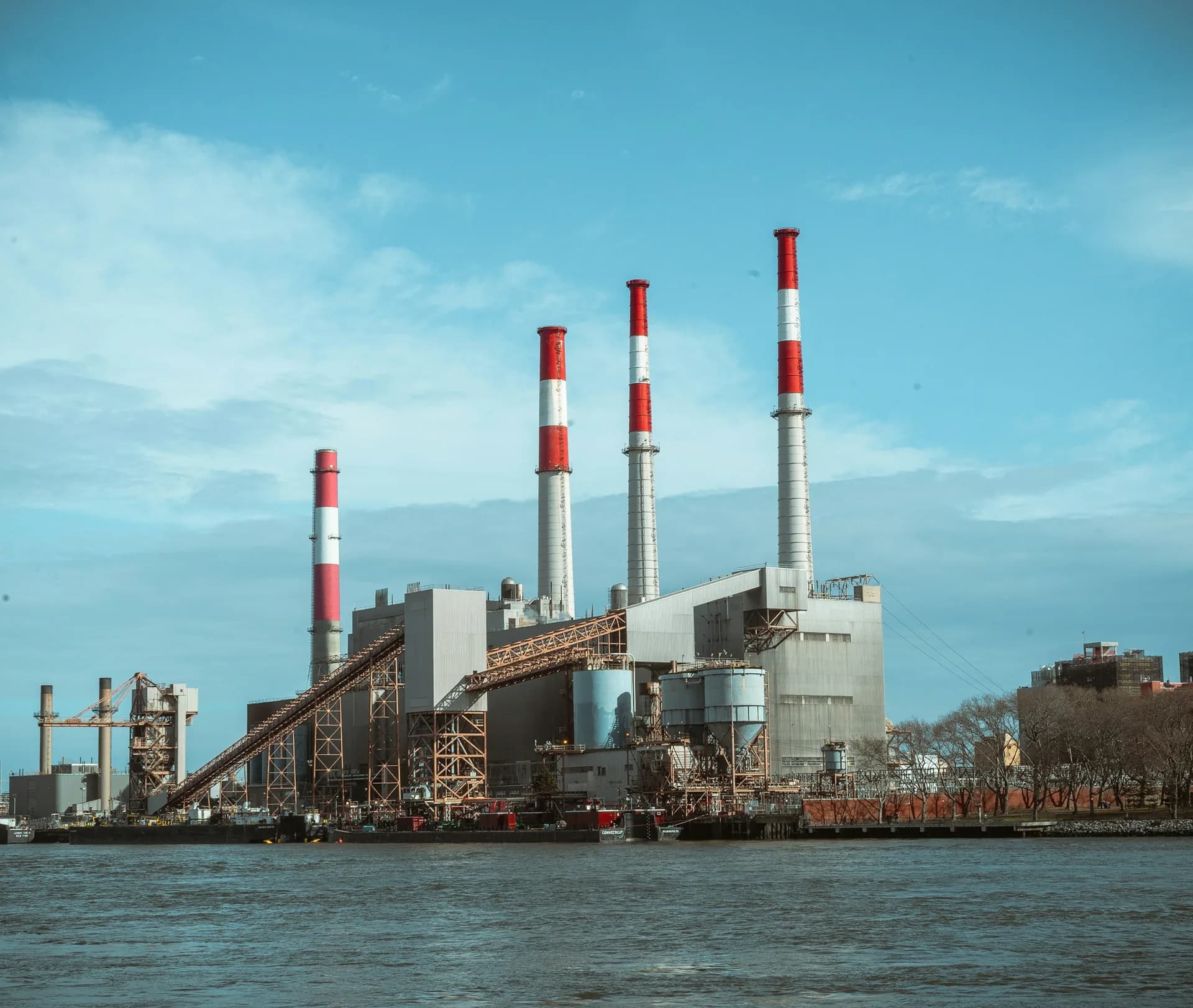 Centrală termoelectrică cu coșuri de fum înalte, pe malul unui râu