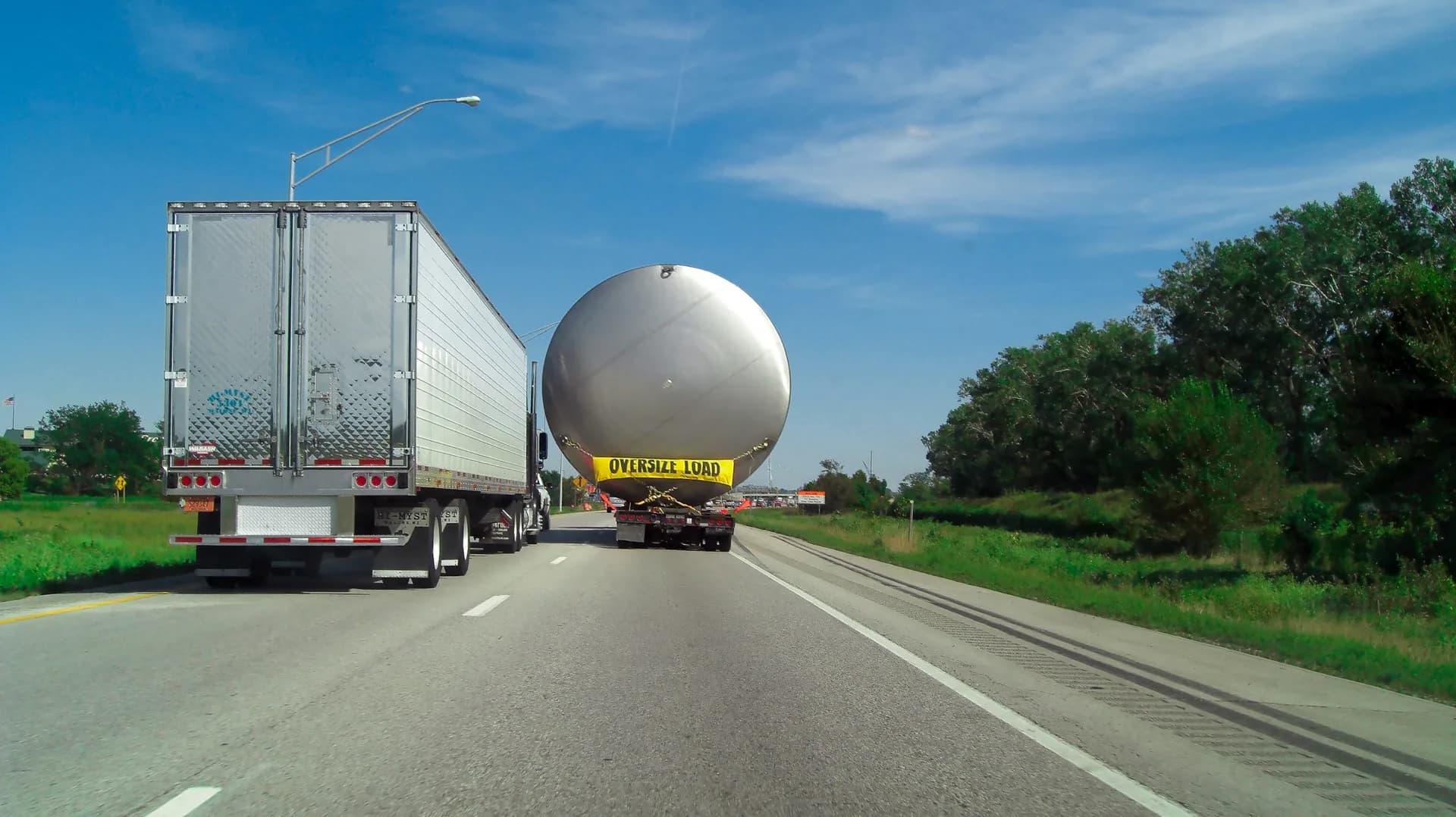 Rezervor sferic industrial transportat pe autostradă, cu semnalizare de marfă agabaritică